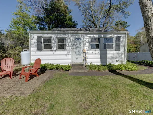 a front view of a house with garden and plants