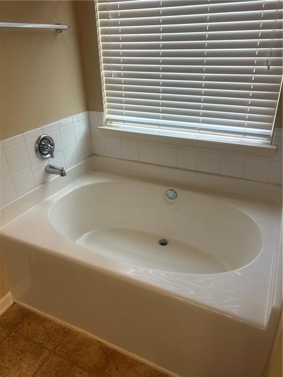 22 Pawnee Trail Fort Mitchell, AL 36856 - Photo 19 of 40 Soaking tub with a tiled surround, chrome fixtures, and a window with blinds