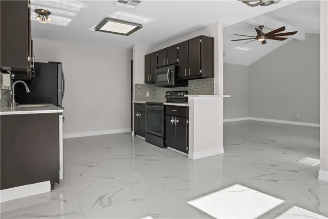 a kitchen with stainless steel appliances a refrigerator and a stove top oven