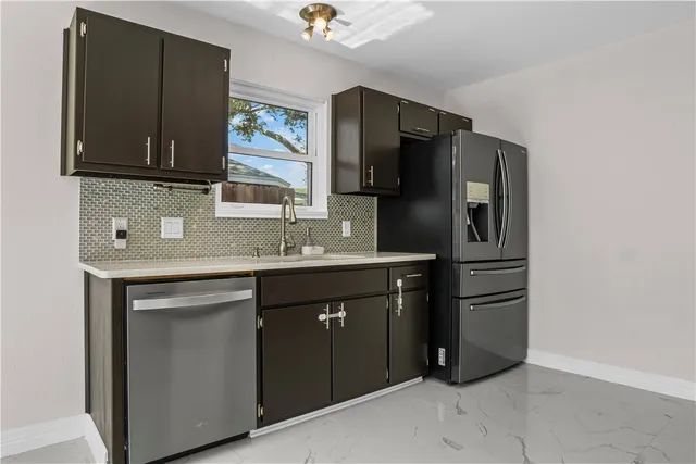 a kitchen with stainless steel appliances granite countertop a refrigerator and a sink