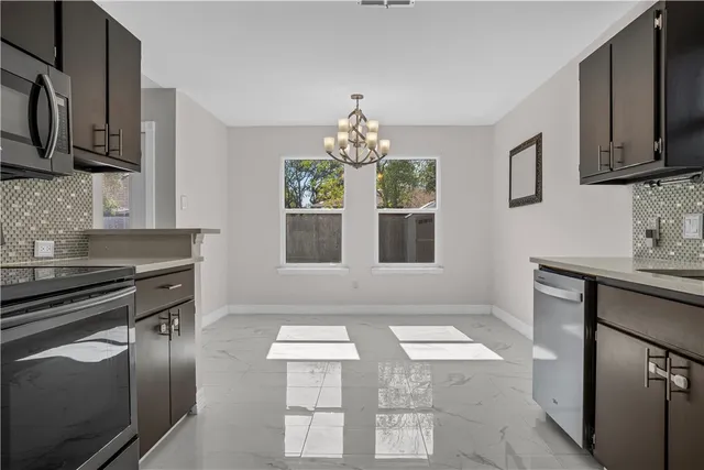 a kitchen with stainless steel appliances granite countertop a stove a sink and a microwave