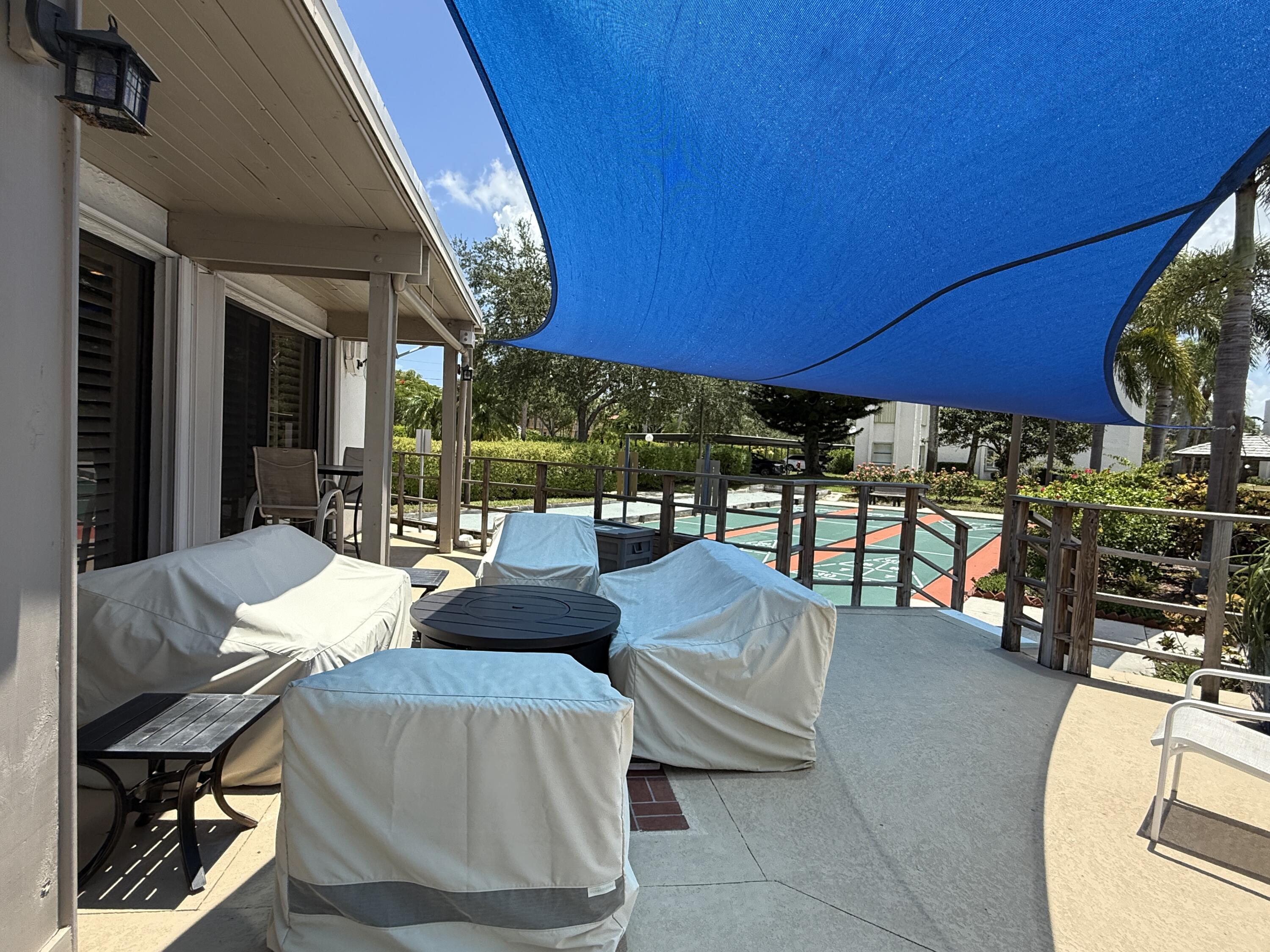 1950 Southwest Palm City Road, Unit 5109 Stuart, FL 34994 - Photo 23 of 41 a view of a patio with table and chairs under an umbrella