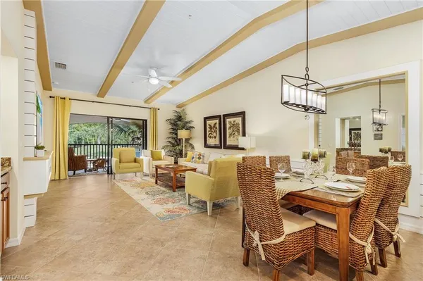 a dining room with furniture a large window and a chandelier