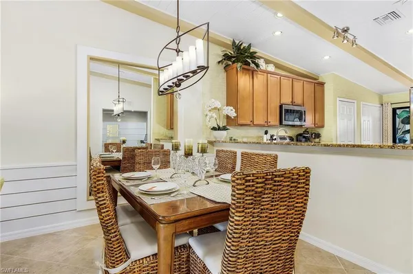 a kitchen with a table chairs microwave and cabinets