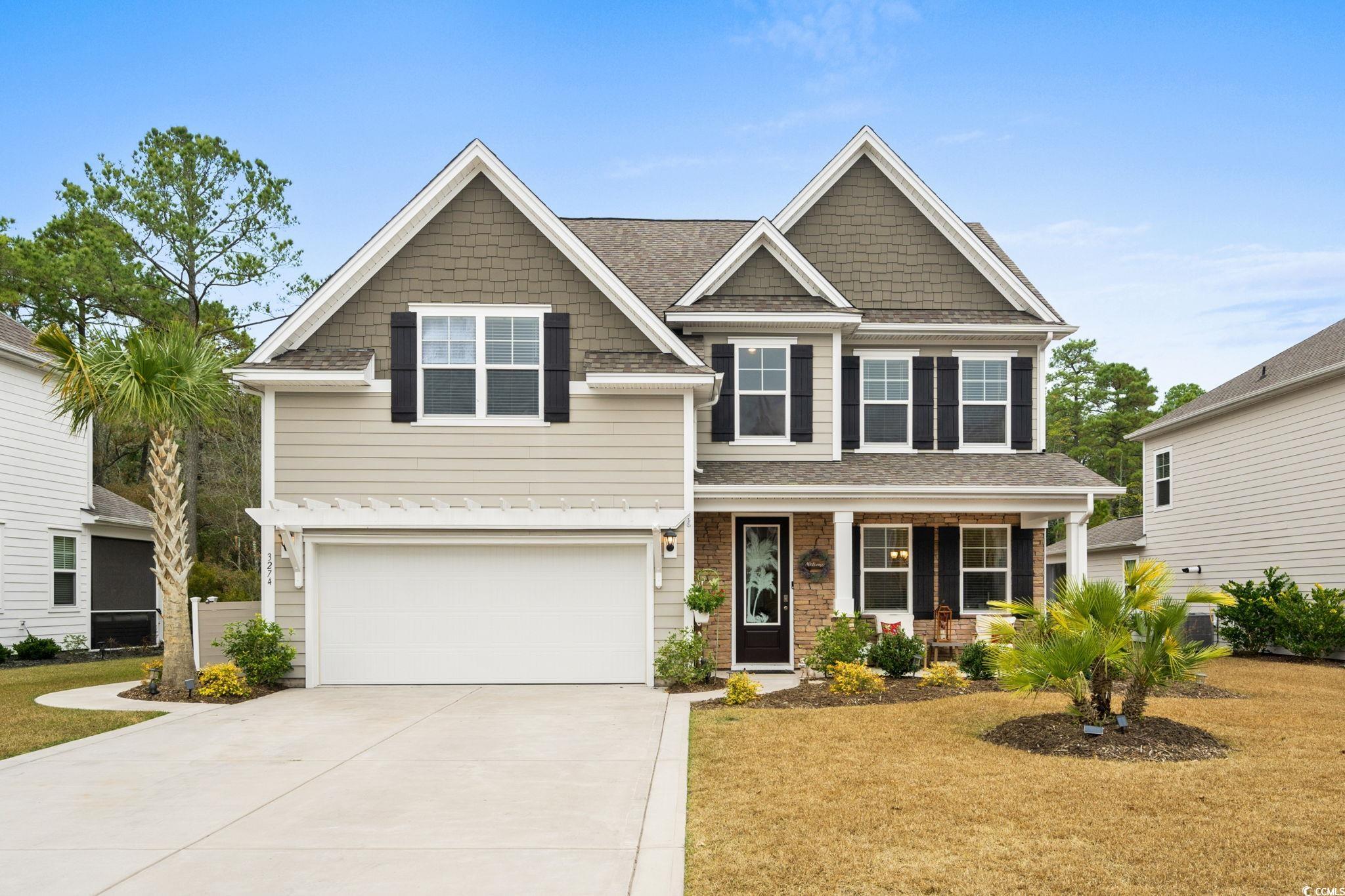 Craftsman-style house with covered porch, an attached garage, concrete driveway, and roof with shingles