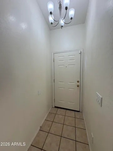 a view of a room with a chandelier fan and cabinets