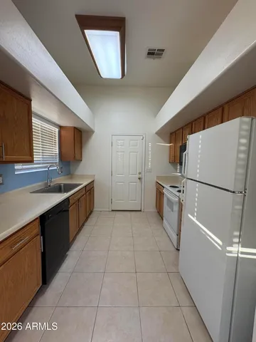 a kitchen with a refrigerator sink and cabinets