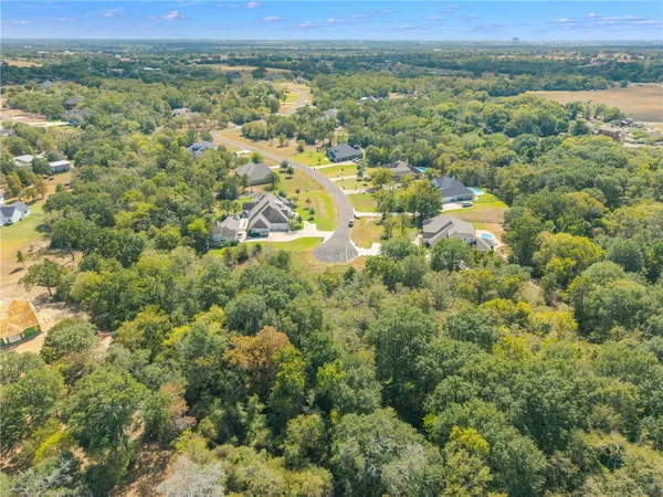 an aerial view of residential houses with outdoor space and trees