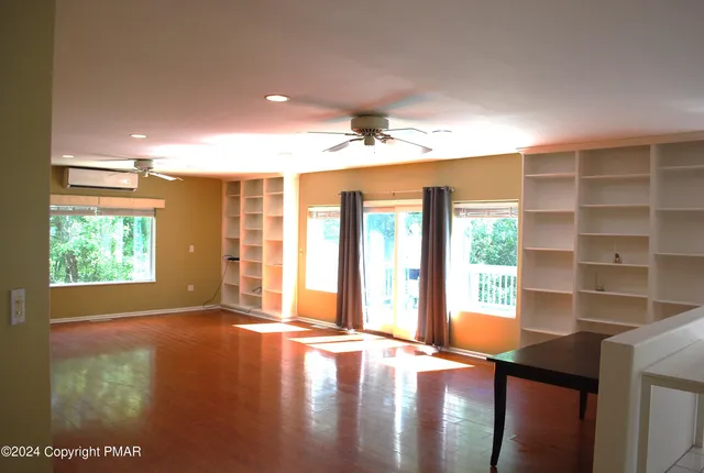a view of empty room with fireplace and fan