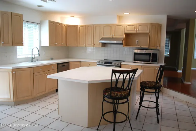 an empty room with windows and fireplace