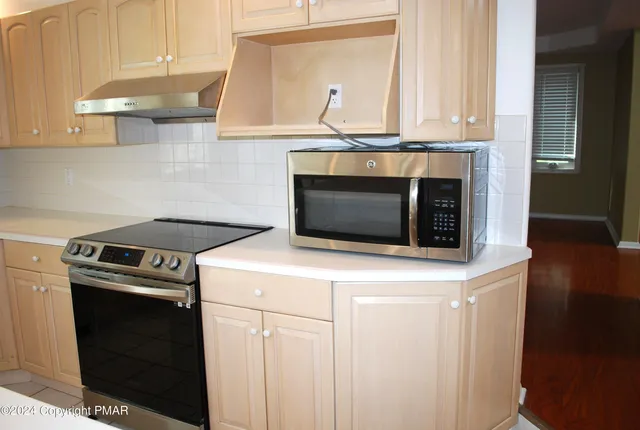 a view of a living room with wooden floor and a large window