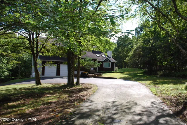 a view of a house with backyard and tree