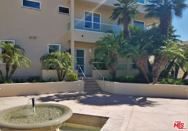 a view of a house with a yard and potted plants