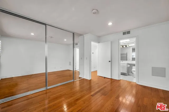 a spacious bathroom with a granite countertop sink a toilet a mirror and shower