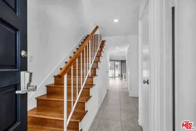 a view of staircase with white walls and wooden floor