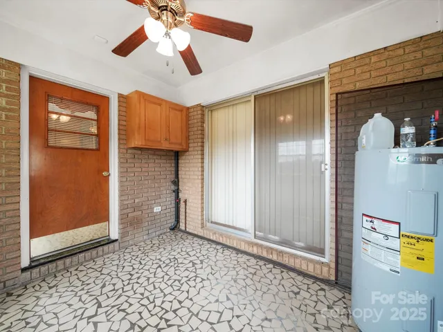 a view of empty room with window and ceiling fan