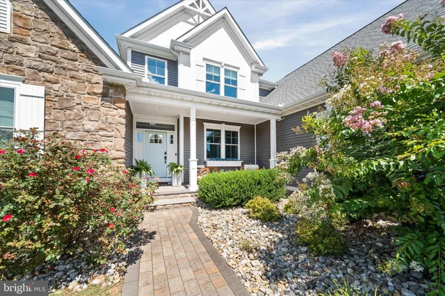 a front view of a house with a yard and potted plants