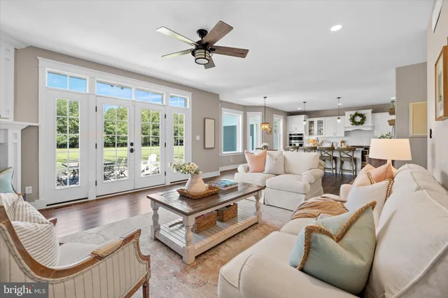 a kitchen with stainless steel appliances a dining table chairs and white cabinets
