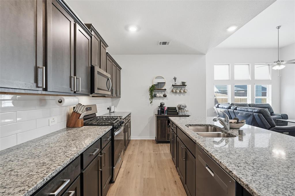 103 Lantern Road Caddo Mills, TX 75135 - Photo 13 of 33 a kitchen with stainless steel appliances granite countertop a sink a stove and a wooden cabinets
