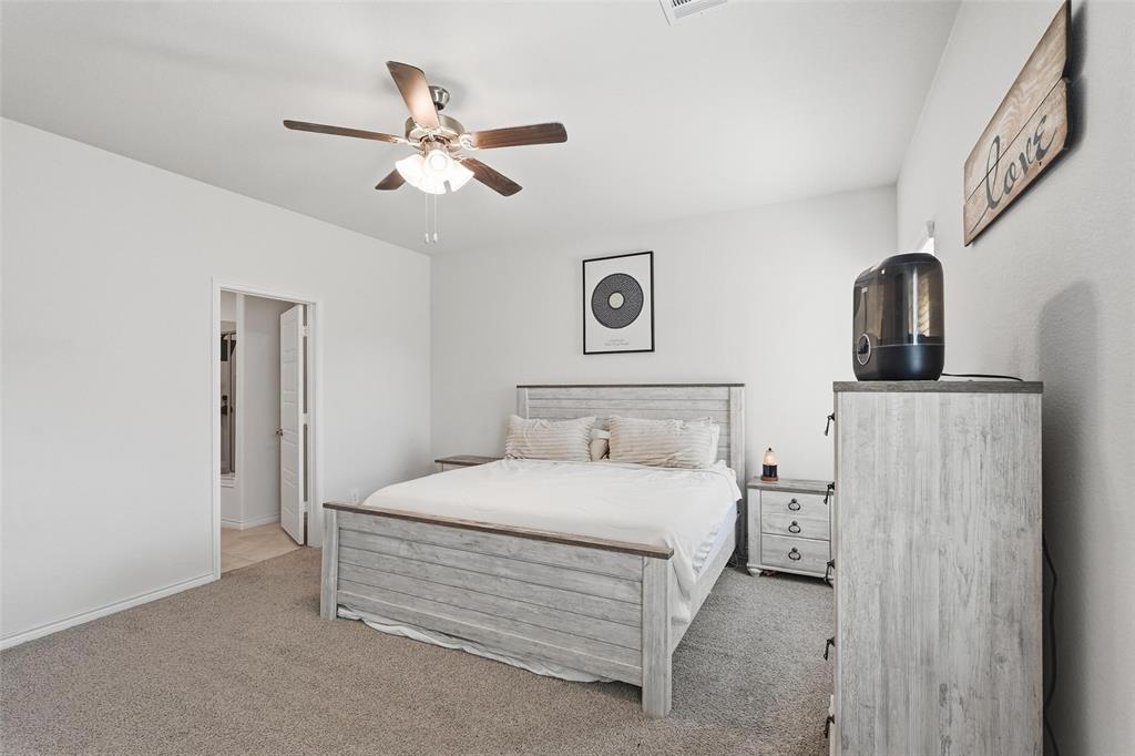 103 Lantern Road Caddo Mills, TX 75135 - Photo 19 of 33 a bedroom with a bed and a chandelier