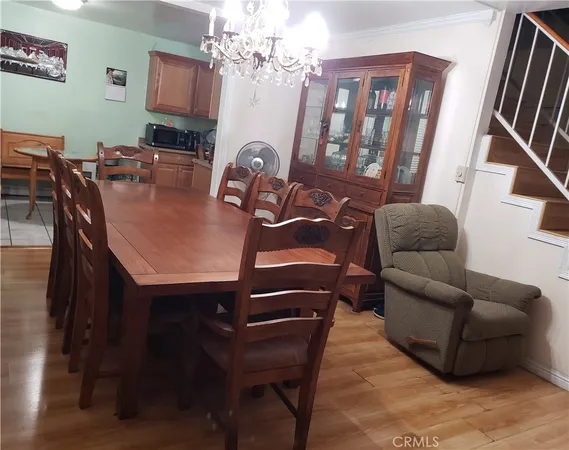 a living room with furniture a flat screen tv and a chandelier