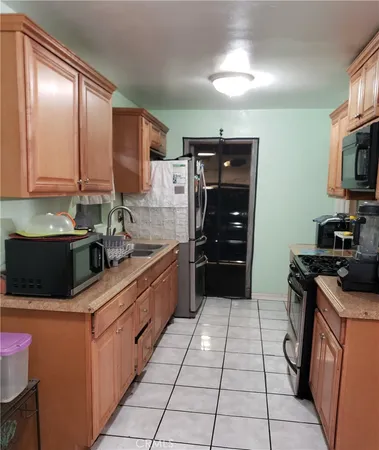 a kitchen with stainless steel appliances granite countertop a refrigerator and a stove top oven