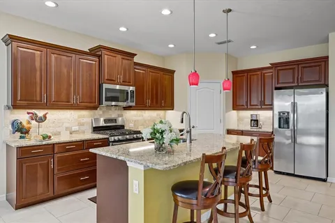 a kitchen with stainless steel appliances granite countertop a refrigerator and a stove top oven
