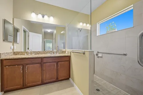 a bathroom with a granite countertop sink a mirror and a shower