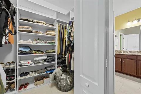 a view of walk in closet with clothes and shoes
