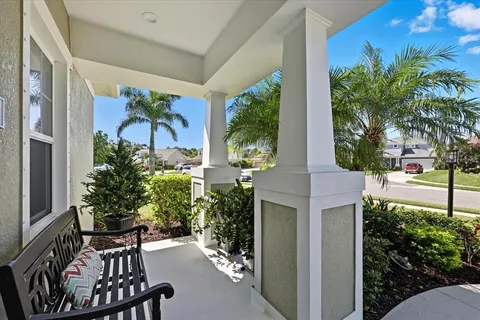 a view of a porch with chairs and potted plants
