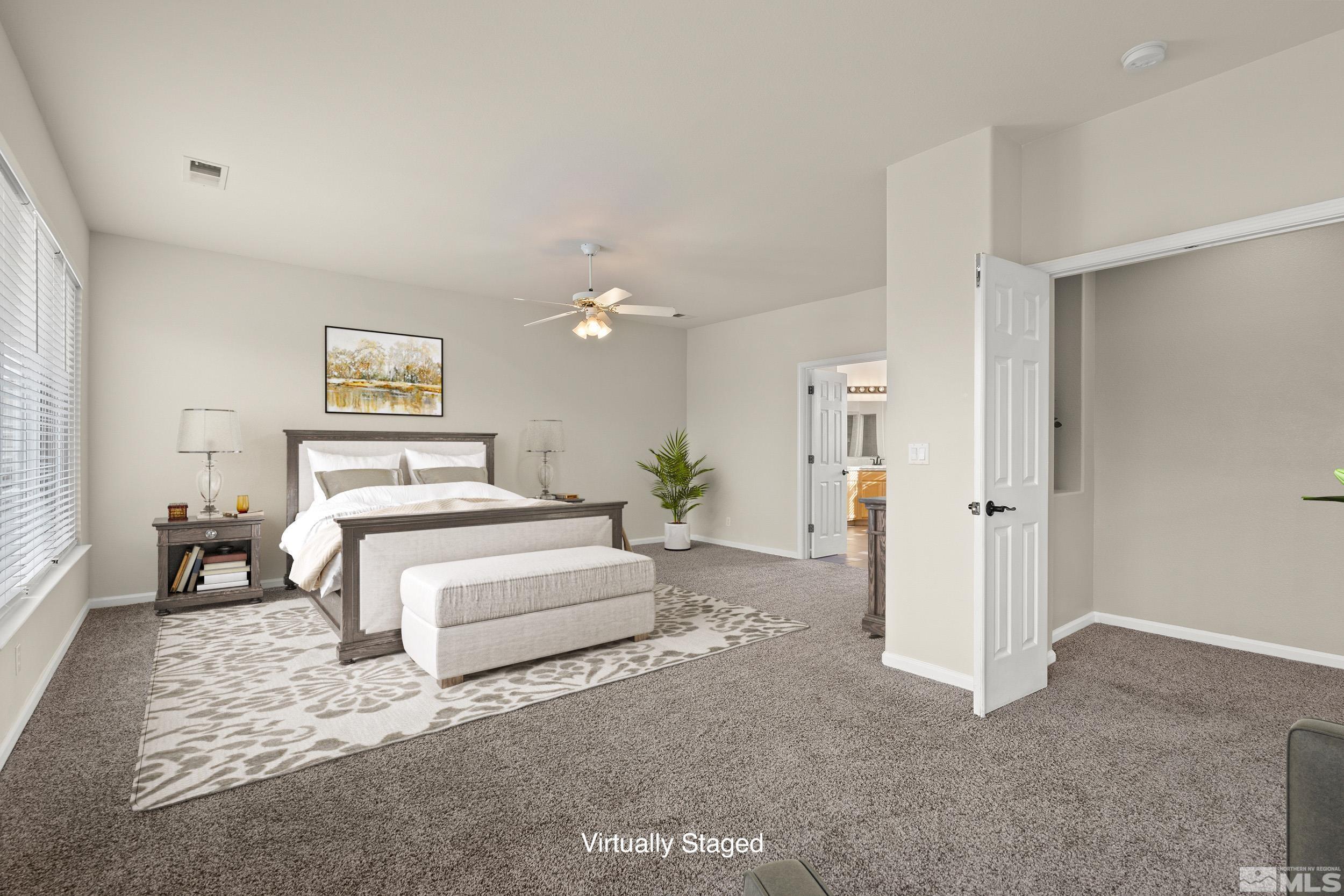 9965 Bandana Way Reno, NV 89521 - Photo 21 of 40 a spacious bedroom with a bed and a chandelier