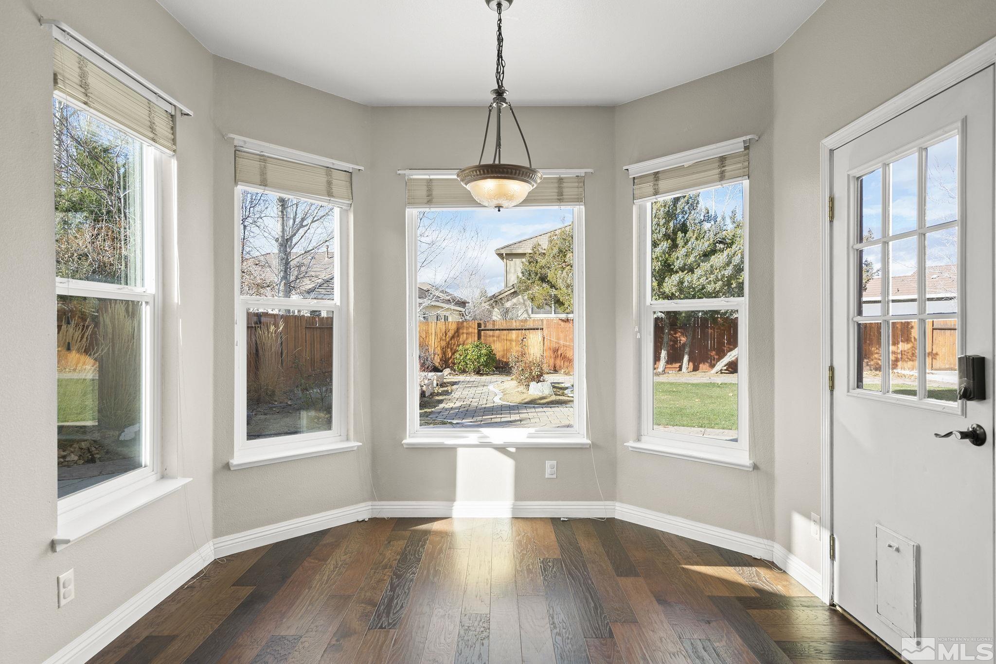 9965 Bandana Way Reno, NV 89521 - Photo 8 of 40 a view of an empty room with wooden floor and a window