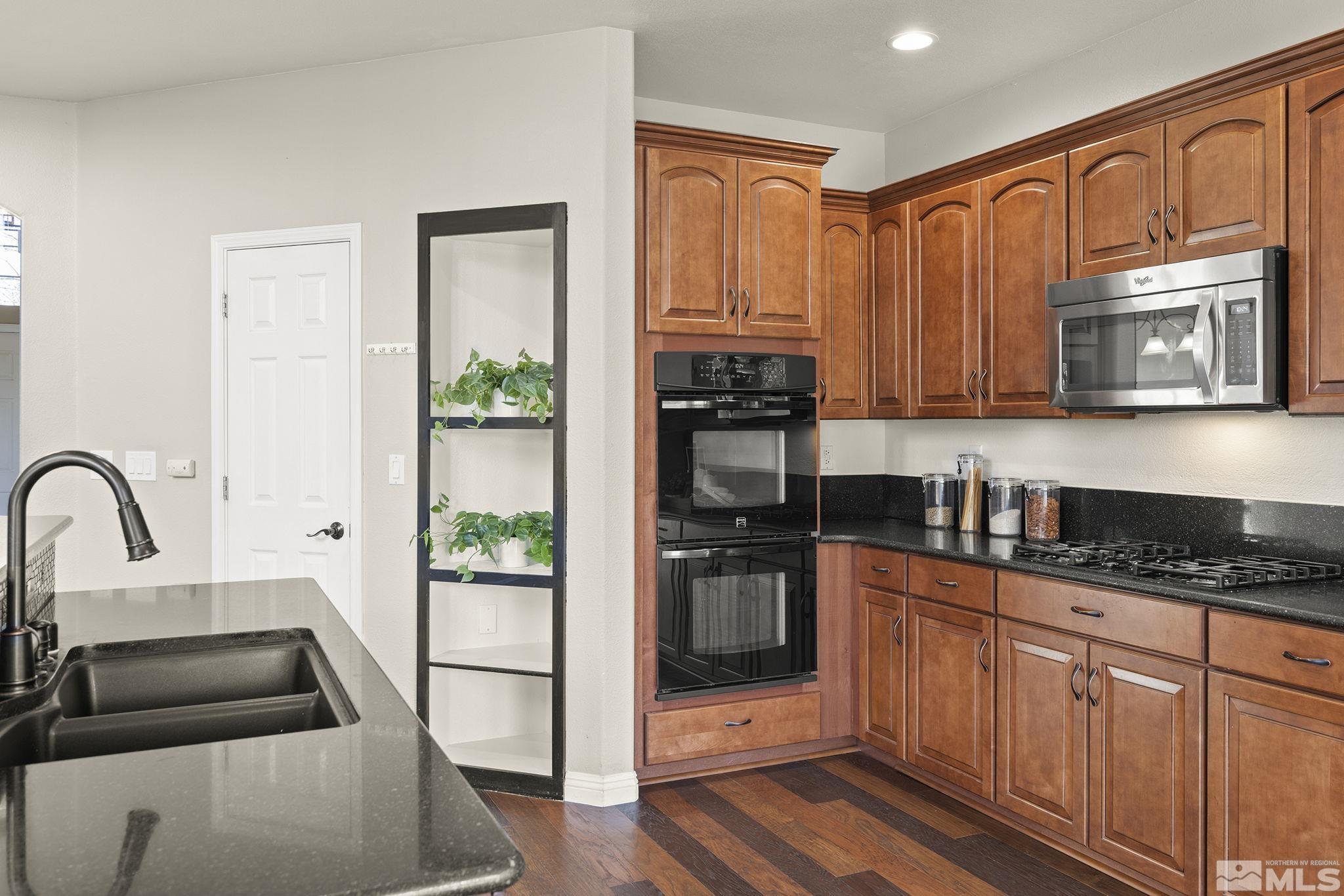 9965 Bandana Way Reno, NV 89521 - Photo 10 of 40 a kitchen with stainless steel appliances granite countertop a stove a sink and a microwave