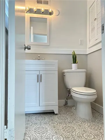 a bathroom with a toilet a sink and mirror