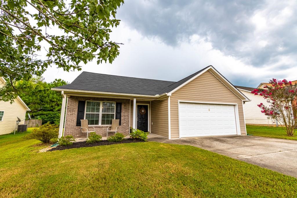 a view of a house with a yard and garage