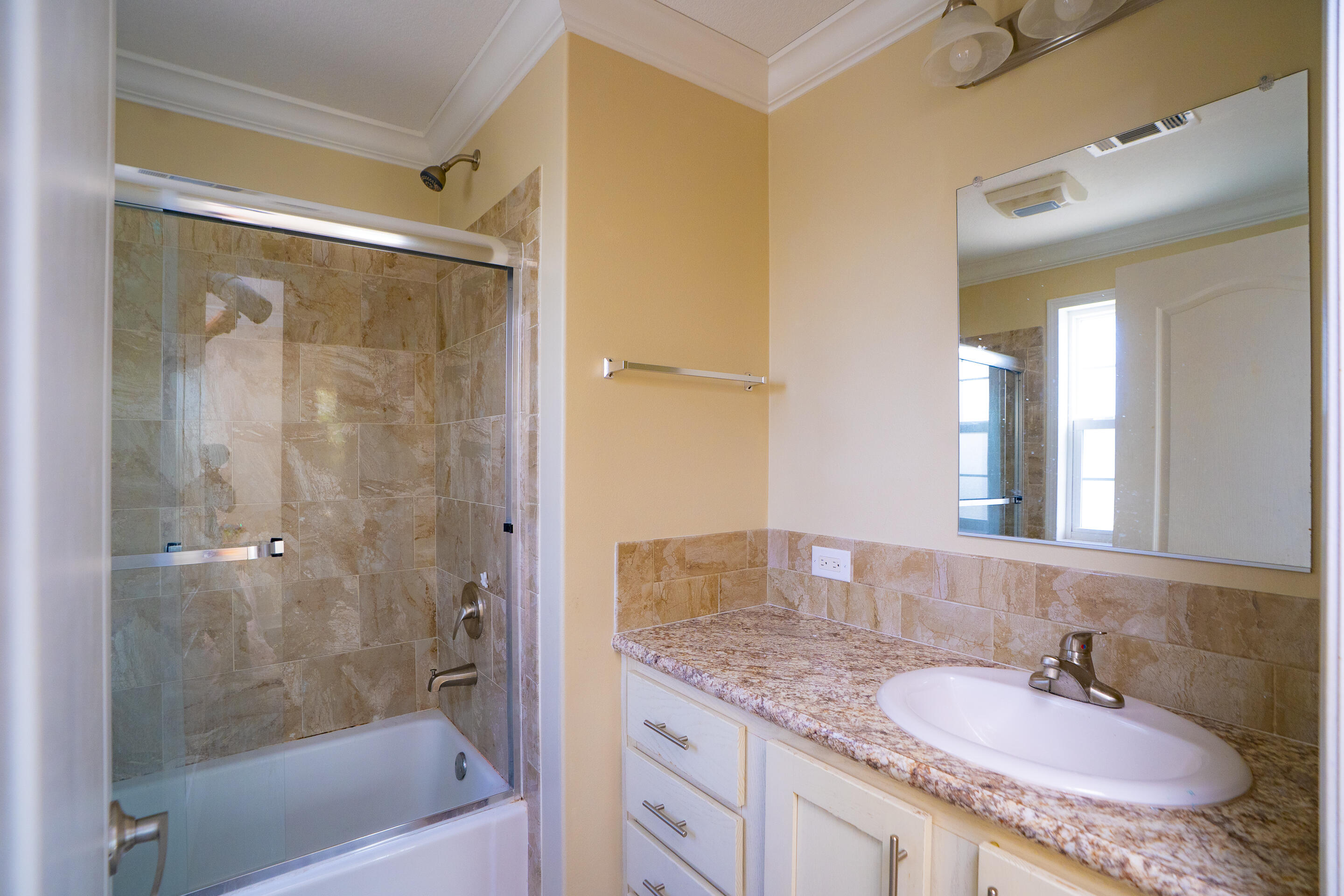 55 Ed Swift Road Key West, FL 33040 - Photo 18 of 23 a bathroom with a granite countertop sink a mirror a bathtub and shower