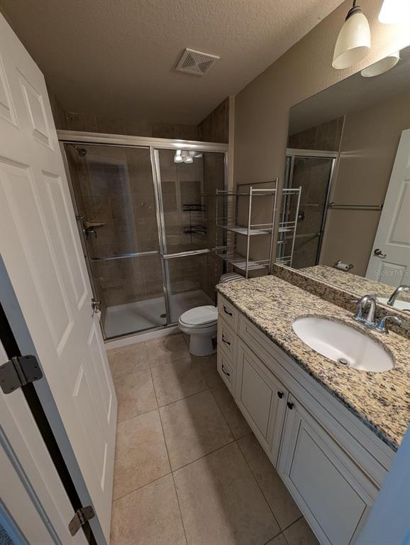 6394 Banyan Boulevard, Unit 204 New Port Richey, FL 34652 - Photo 12 of 25 a bathroom with a granite countertop sink a toilet and a shower
