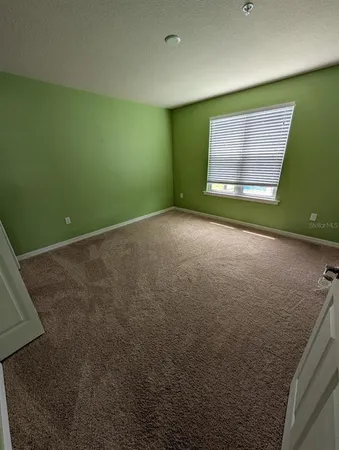 a spacious bathroom with a granite countertop sink a toilet a mirror and shower