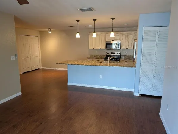 a view of a kitchen with a sink and dishwasher a refrigerator with wooden floor