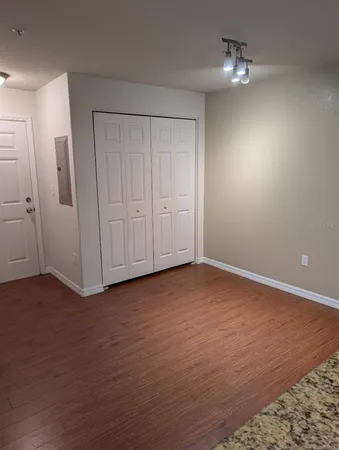 a view of empty room with wooden floor