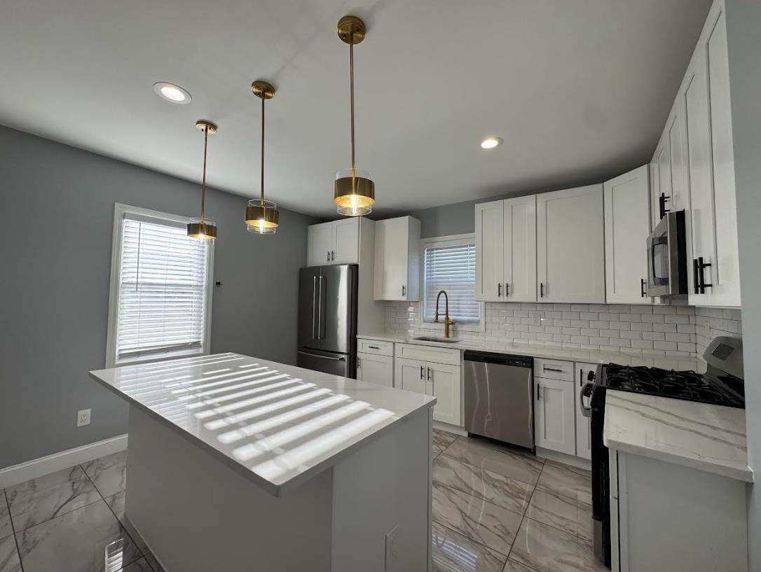 243 Hamilton Place, Unit 2 Hackensack, NJ 07601 - Photo 2 of 9 a kitchen with stainless steel appliances kitchen island a sink stove and refrigerator