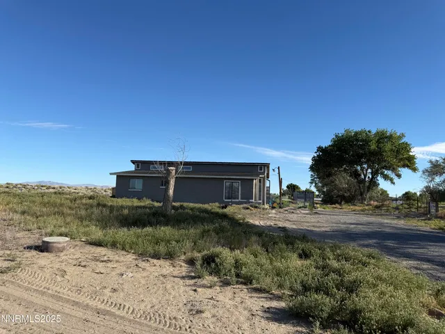 a view of a dry yard with wooden fence