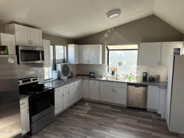a kitchen with granite countertop a refrigerator stove top oven and sink