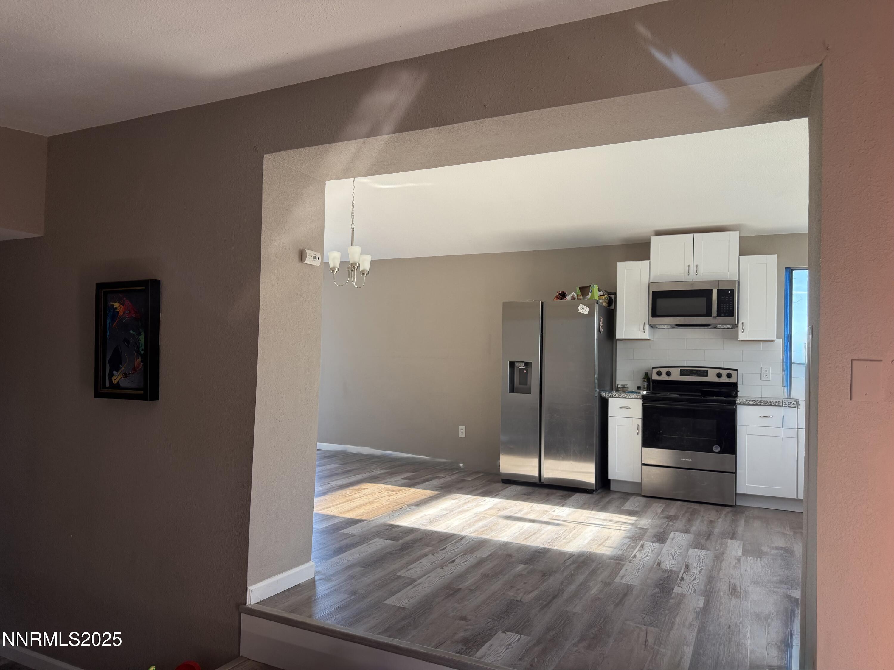 6722 Power Line Road Fallon, NV 89406 - Photo 8 of 15 a view of a kitchen with an empty space stove fridge and wooden floor