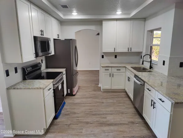 a kitchen with stainless steel appliances a refrigerator and a stove top oven