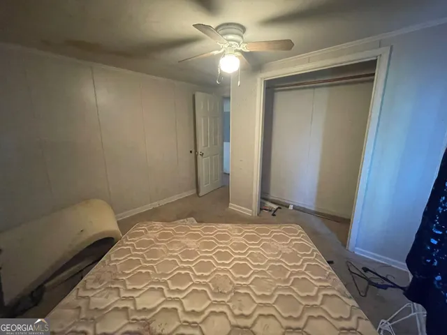 a bedroom with a bed and a chandelier fan