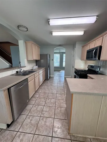 a kitchen with a sink a stove top oven and cabinetry