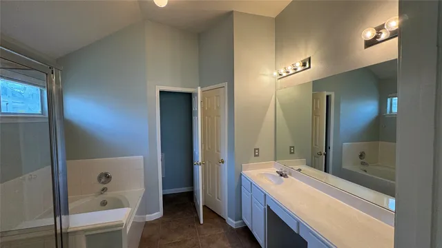 a bathroom with a tub shower and sink