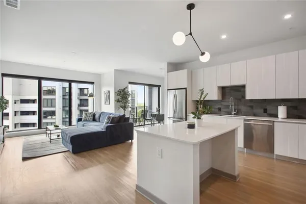 a kitchen with kitchen island a large counter space a sink appliances and a counter top space