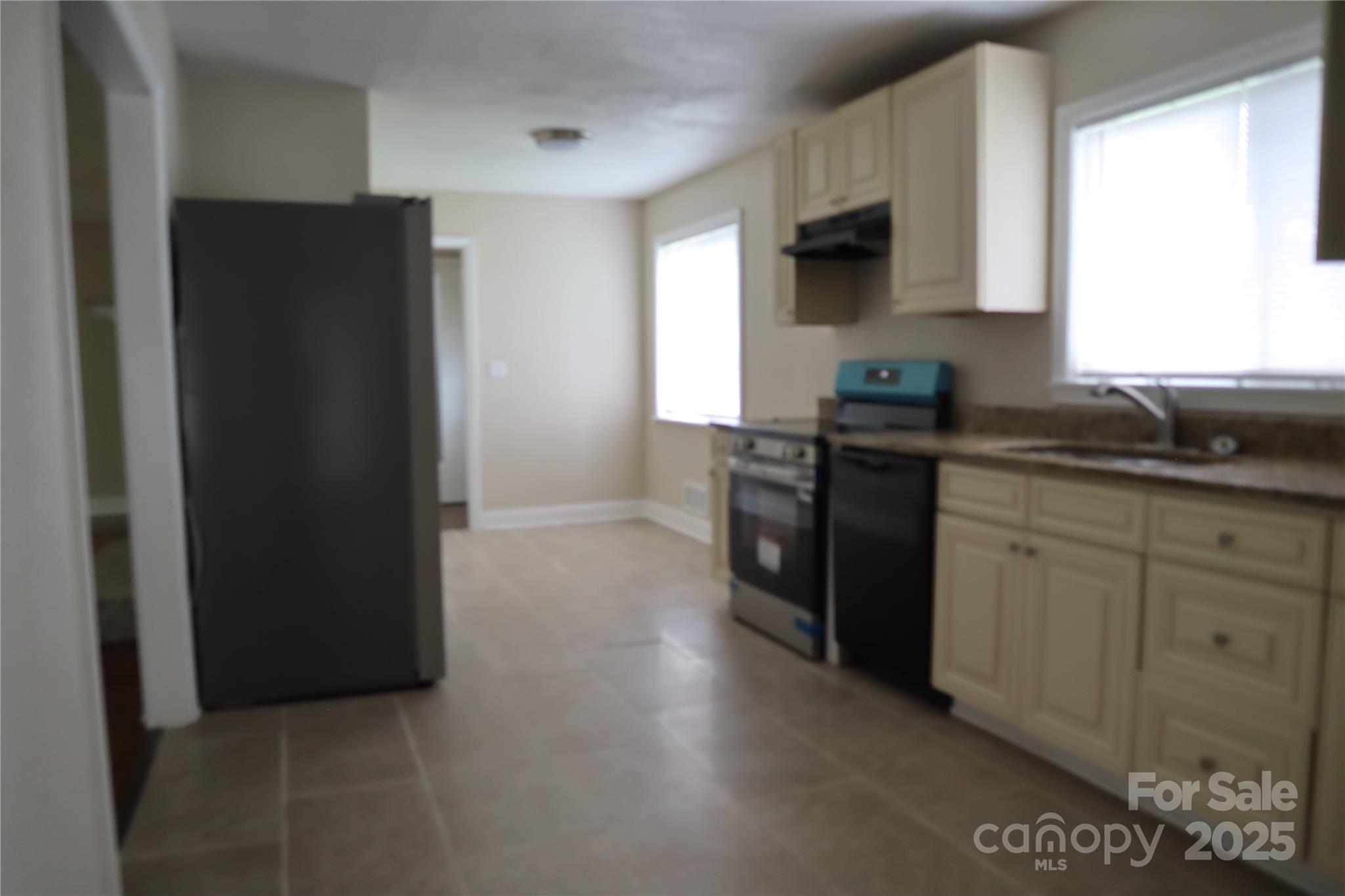 1703 Tyvola Road Charlotte, NC 28210 - Photo 3 of 17 a kitchen with stainless steel appliances granite countertop a refrigerator and a stove top oven